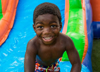 Boy on colorful water slide - Party Rentals in Athens, GA