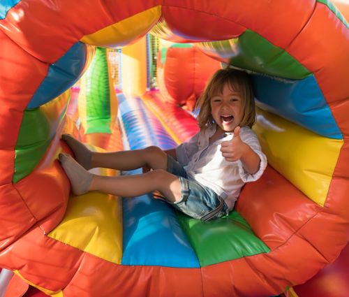 Girl in obstacle course rental tube giving thumbs up