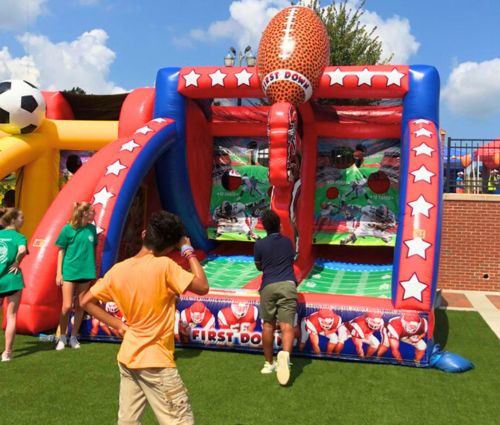 Boy tries interactive inflatable football game rental challenge from Jumptastic in Lawrenceville